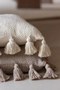 Coussin pompoms beige